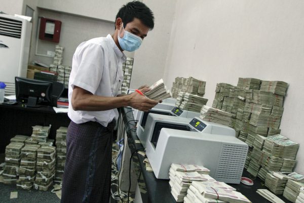 An employee counts Myanmar kyat banknotes in a bank in Yangon (Photo: Reuters/Minzayar).