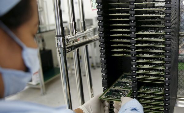 A worker of Ayala Corp's Integrated Micro-Electronics Inc. (IMI) removes computer chips from a shelve at an electronics assembly line in Binan, Laguna south of Manila, Philippines 20 April, 2016 (Photo: Reuters/Erik De Castro).