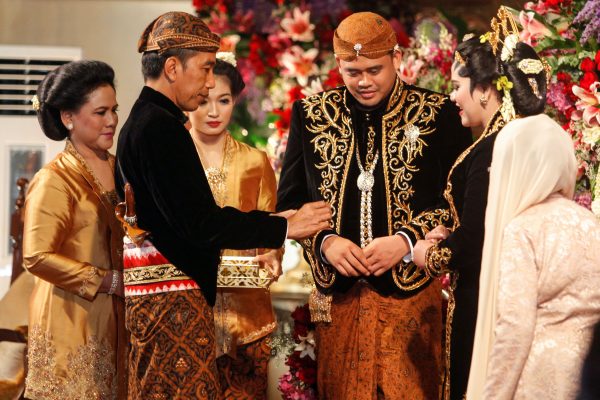 Indonesia's President Joko Widodo (2nd L), accompanied by first lady Iriana Widodo (L) and daughter-in-law Selvi Ananda (3rd L), looks at his daughter Kahiyang Ayu's (2nd R) wedding ring as his new son-in-law Bobby Nasution (3rd R) is seen during their wedding ceremony in Solo, Central Java, Indonesia, 8 November, 2017 (Antara Foto/Maulana Surya/ via Reuters).