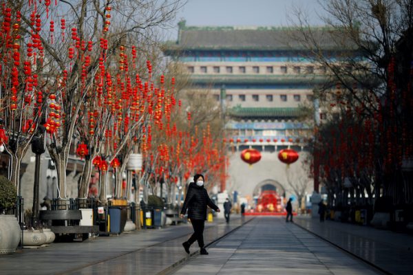 A woman wearing a face mask walks on the Qianmen pedestrian street in the morning after the extended Lunar New Year holiday caused by the novel coronavirus outbreak, in Beijing, China 10 February, 2020 (Photo: Reuters/Carlos Garcia Rawlins).
