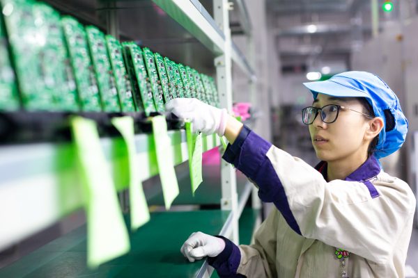 A worker inspects and arranges production for elevator signal system at a factory of Jiangsu WELM Technology Co., Ltd. in Hai'an city, east China's Jiangsu province, 24 August 2020 (Photo: Reuters).