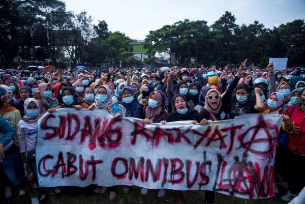 People hold a sign reading ‘The people's assembly revokes the omnibus law’ as members of Indonesian trade unions and university students protest against the government's proposed labor reforms in a controversial ‘jobs creation’ bill in Sukabumi, West Java Province, Indonesia, 7 October 2020 (Photo: Reuters/Antara Foto/Iman Firmansyah).