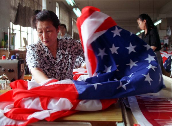 A seamstress at the Beijing Red Flag factory in Beijing sews together the red and white stripes of an American Flag (Photo: Reuters).