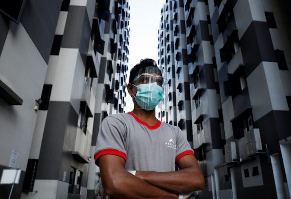 A migrant worker listens as officials give a tour of a dormitory, amid the coronavirus disease (COVID-19) outbreak in Singapore 15 May, 2020 (Photo: Reuters/Edgar Su).