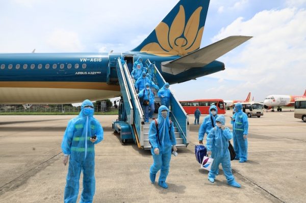 People apply preventive measures during the first domestic flight, carried out by Vietnam Airlines to transport tourists stranded in the central city of Da Nang affected by COVID-19 at the Airport Noi Bai International in Hanoi, Vietnam on 12 August, 2020 (Photo: Reuters/VNA).