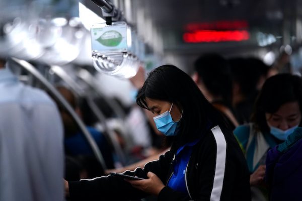 A passenger wearing a face mask following the coronavirus disease (COVID-19) outbreak uses her phone on a subway train in Beijing, China 29 September, 2020 (Photo: Reuters/Tingshu Wang).