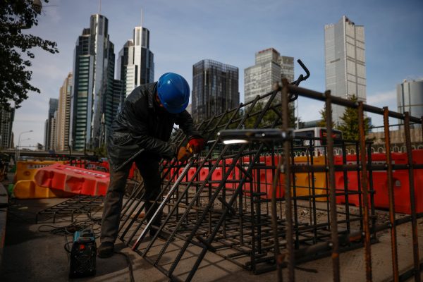 Workers prepares an iron grid for welding at a construction site in the Central Business District (CBD) following an outbreak COVID-19 in Beijing, China, 27 October 2020 (Photo: Reuters/Thomas Peter).
