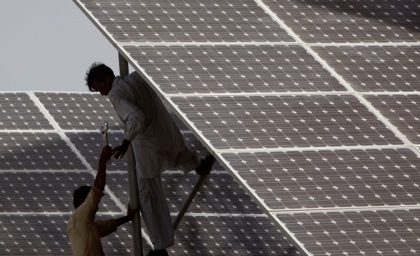Technicians work on solar panels at a power station in Hub, Pakistan, 19 June 2010 (Photo: Reuters)