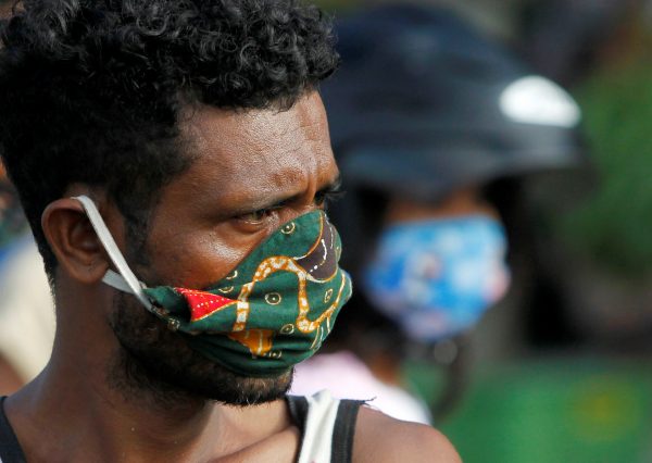 A vendor wearing a protective mask looks on as he waits for customers at a traditional market, after the government announced new cases of coronavirus disease (COVID-19), in Dili, East Timor, 16 April 2020 (Photo: Reuters/Lirio da Fonseca).