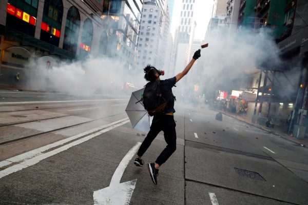 An anti-government protester reacts as police fire tear gas during a march billed as a global 'emergency call' for autonomy, Hong Kong, 2 November 2019. (Photo: Reuters/Thomas Peter)