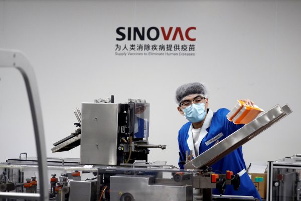 A man works in the packaging facility of Chinese vaccine maker Sinovac Biotech, developing an experimental COVID-19 vaccine, during a government-organized media tour in Beijing, China, 24 September 2020 (Photo: Reuters/Thomas Peter).