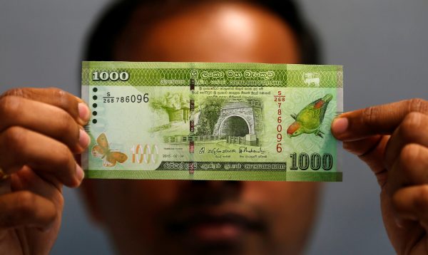A man shows a thousand rupee note in this illustration, 7 September 2018 (Photo: Reuters/Dinuka Liyanawatte).