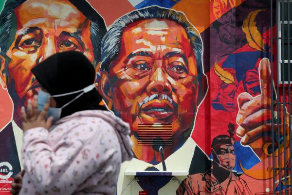 A woman passes by a mural depicting Malaysia's Prime Minister Muhyiddin Yassin in Kuala Lumpur, Malaysia, 27 October 2020. (Photo: Reuters/Lim Huey Teng).