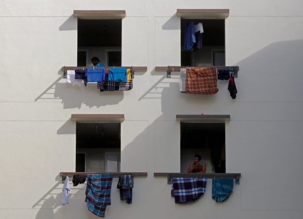 Migrant workers look out of windows in a dormitory, amid the COVID-19 outbreak in Singapore, 15 May 2020 (Photo: Reuters/Edgar Su).