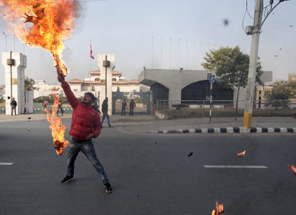 A protester burns the effigy of Nepal's Prime Minister Khadga Prasad Sharma Oli, after the parliament was dissolved and general elections were announced to be held in April and May 2021, over a year ahead of schedule, outside the parliament building in Kathmandu, Nepal, 20 December 2020 (Photo: Reuters/Navesh Chitrakar).