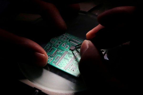 A researcher plants a semiconductor on an interface board, Beijing, China, 29 February 2016 (Photo: Reuters/Kim Kyung-Hoon).