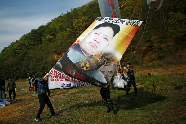 Park Sang-hak (L), a North Korean defector and leader of an anti-North Korea civic group, holds a banner depicting North Korean leader Kim Jong Un with nuclear, tied on a balloon, near the demilitarized zone in Paju, South Korea, 29 April, 2016 (Photo: Reuters/Kim Hong-Ji).