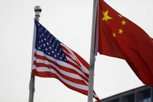 Chinese and U.S. flags flutter outside the building of an American company in Beijing, China 21 January 2021 (Photo: Reuters/Tingshu Wang).