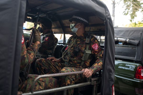 Myanmar soldiers sit inside a vehicle as they guard in front of a Hindu temple in the downtown area in Yangon, Myanmar, 2 February 2021 (Photo: Reuters/Stringer).