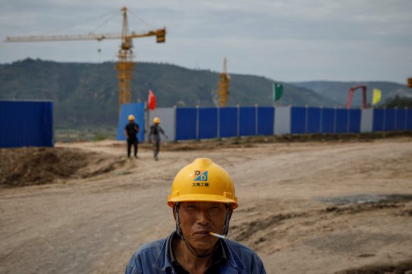 A worker stands outside a construction site of the Xinzhuang coal mine that is part of Huaneng Group's integrated coal power project near Qingyang, Ning County, Gansu province, China, 19 September, 2020 (Photo: Reuters/Thomas Peter).