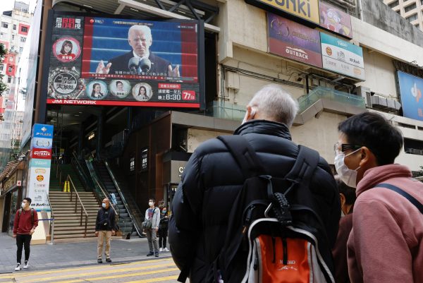 People look at a TV screen showing news of US President Joe Biden after his inauguration, in Hong Kong, China, 21 January 2021 (Photo: Reuters/Tyrone Siu).