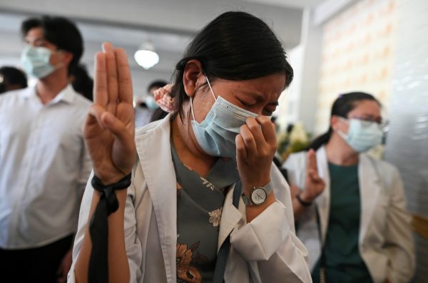 A woman shows a three-finger salute as she attends the funeral of Khant Nyar Hein, a 17-year-old medical student who was shot and killed during the security force crack down on anti-coup protesters in Yangon, Myanmar, 16 March 2021 (Photo: Reuters/Stringer).
