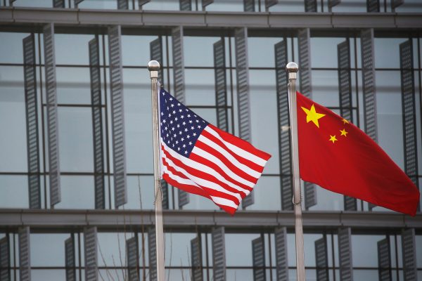 Chinese and U.S. flags flutter outside the building of an American company in Beijing, China, 21 January 2021. (Photo: Reuters/Tingshu Wang).