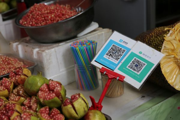 View of a QR code at a stall supported by mobile payment service Alipay of Alibaba Group, left, and WeChat Payment of Tencent at a free market in Xi'an city, northwest China's Shaanxi province, 21 August 2017 (Photo: Reuters).