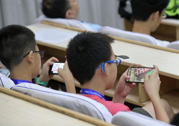 Primary school students play video games on smartphones in Zhengzhou city, central China's Henan province, 17 July 2018 (Photo: Reuters).
