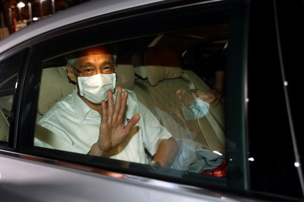 Singapore's Prime Minister Lee Hsien Loong waves from a car as he leaves a People's Action Party branch office, as ballots are being counted during the general election, in Singapore 11 July 2020 (Photo: Reuters/Edgar Su).
