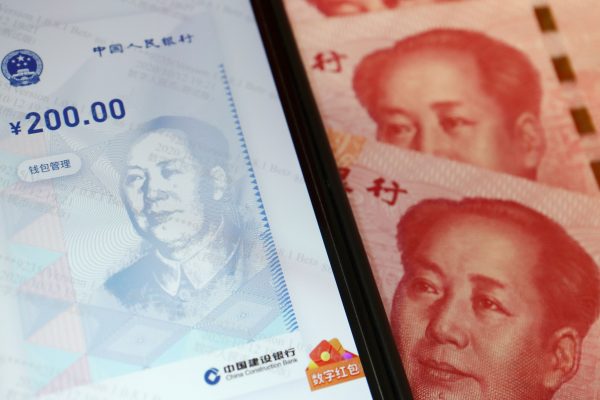 China's official app for digital yuan is seen on a mobile phone next to 100-yuan banknotes, 16 October 2020 (Photo: Reuters/Florence Lo).