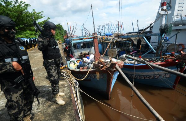 Two Indonesian officers stand near a vessel from Vietnam which is secured at the Pier of the Pontianak Fishery and Marine Resources Monitoring Station in Kubu Raya Regency, West Kalimantan Province, Indonesia, 12 April, 2021 (Photo: Arief Nugroho/Opn Images/Cover Images via Reuters).