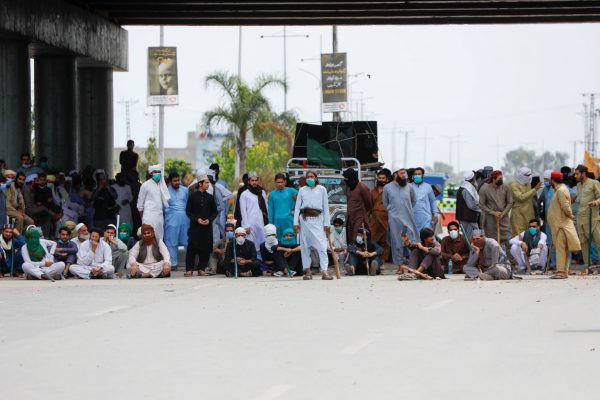 Supporters of the Tehreek-e-Labaik Pakistan (TLP) Islamist political party carry sticks as they block a road during a protest against the arrest of their leader, in Peshawar, Pakistan, 13 April 2021 (Photo: Reuters/Fayaz Aziz).