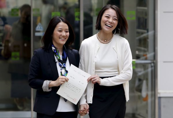 Hiroko Masuhara (L) and her partner Koyuki Higashi hold their partnership certificate as they walk out from the Shibuya ward office after the ward office issued the nation's first same sex partnership certificates in Tokyo, Japan, 5 November 2015 (Photo: Reuters/Yuya Shino).