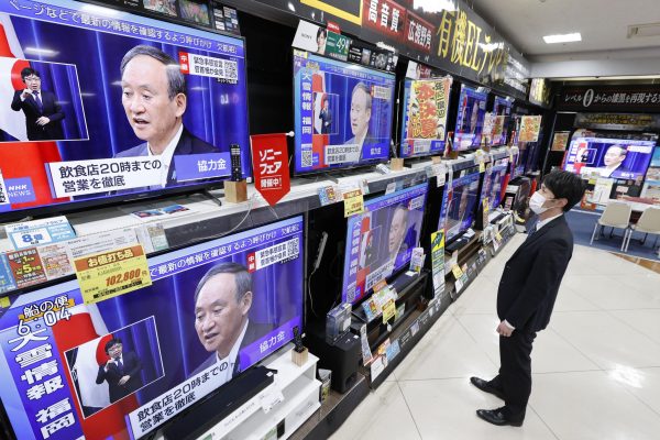TV screens at an electronics store in Fukuoka, southwestern Japan, show Prime Minister Yoshihide Suga speaking at a press conference on 7 January 2021 (Photo: Kyodo via Reuters).