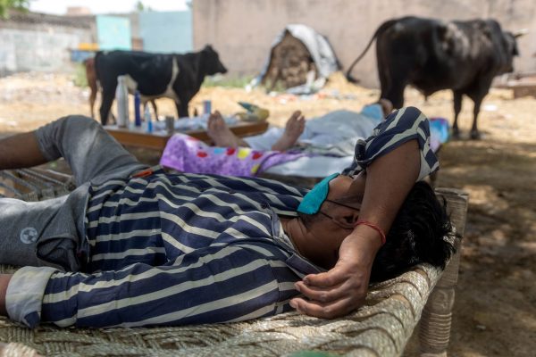 Villagers with breathing difficulties rest in cots as they receive treatment at a makeshift open-air clinic, Uttar Pradesh, India, 16 May 2021 (Photo: Reuters/Danish Siddiqui).