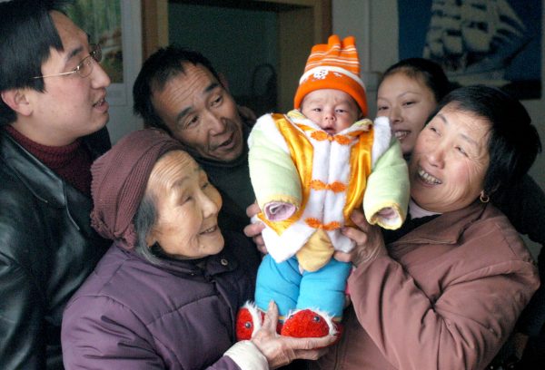 Parents, grandparents and a great grandmother hold up a baby at a home in Yangguidian village, Hubei province, 9 February 2005 (Photo: Reuters).
