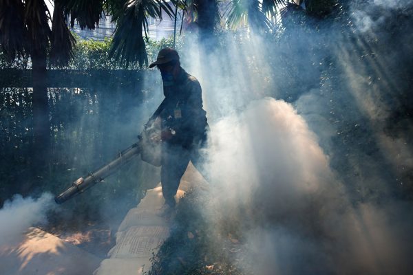 A worker sprays insecticide for mosquitos at a village in Bangkok, Thailand, 12 December 2017 (Photo: Reuters/Athit Perawongmetha).