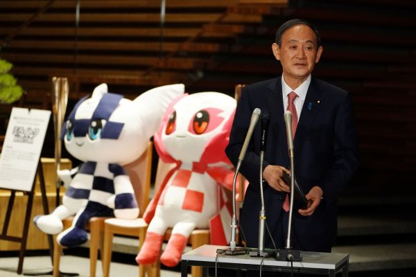 Japanese Prime Minister Yoshihide Suga next to the mascots of Tokyo 2020 Olympic and Paralympic Games in Tokyo, Japan, 9 April 2021 (Photo: Eugene Hoshiko/Pool via Reuters).