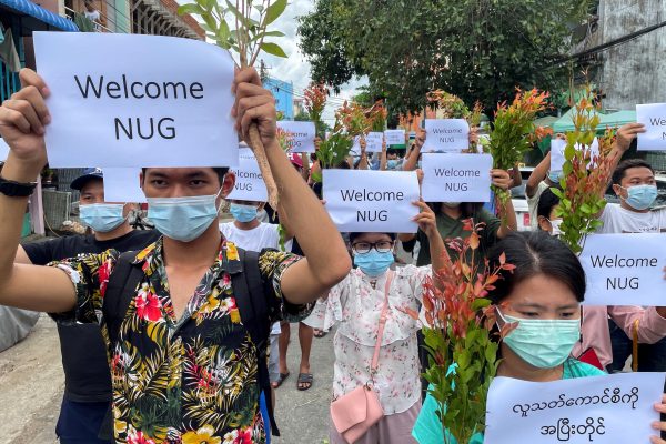 Anti-government protesters hold placards to show their support and welcome the new National Unity Government, Yangon, Myanmar, 17 April 2021 (photo: Reuters/Stringer)