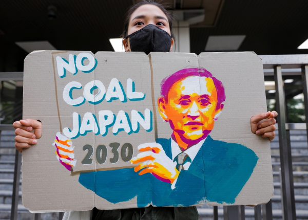 A young climate activist holds a banner during a rally calling on policy makers to raise the target of greenhouse gas reduction outside the Ministry of Economy, Trade and Industry, to mark the World Earth Day in Tokyo, Japan 22 April 2021 (Photo: Reuters/Androniki Christodoulou).