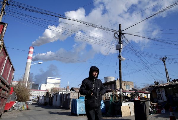 A man walks near a coal-fired power plant, Harbin, 27 November 2019 (Photo: REUTERS/Jason Lee).