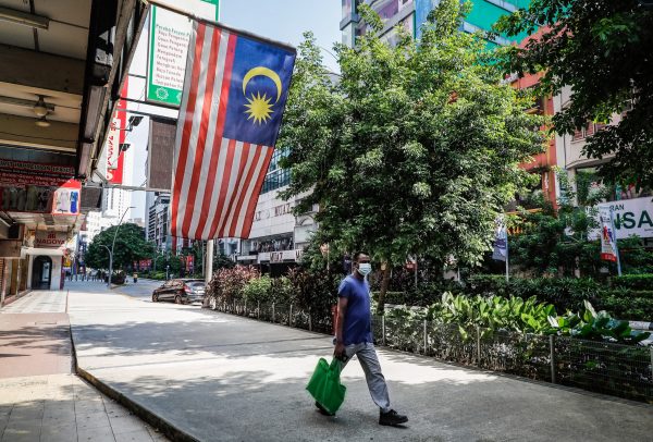 A man wearing a face mask as a preventive measures against the spread of the coronavirus (COVID-19) walks along an empty street in China Town, Kuala Lumpur, Malaysia, 17 July 2021. (Photo: REUTERS/Wong Fok Loy / SOPA Images/Sipa USA)
