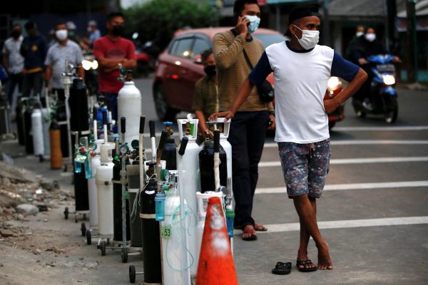 People wearing protective masks queue to refill oxygen tanks as Indonesia experiences an oxygen supply shortage amid a surge of COVID-19 cases, at a filling station in Jakarta, Indonesia, July 5, 2021. (Photo: REUTERS/Willy Kurniawan)