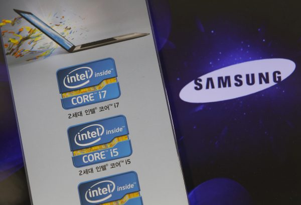 The Samsung Electronics logo is seen on a laptop computer screen (R) in front of an advertisement board promoting Intel processors at a store in Seoul 21 June 2012 (Photo: Reuters/Choi Dae-woong).