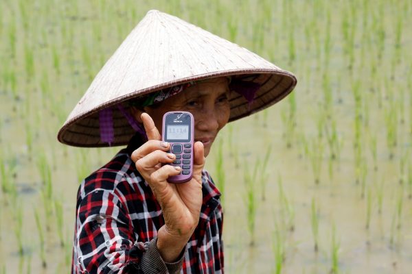 A farmer shows her Nokia cell phone on a rice pady outside Hanoi, Vietnam, 13 July 2017 (Photo: Reuters/Kham)
