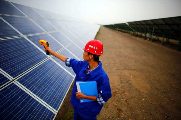 A worker inspects solar panels at a solar farm in Dunhuang, 950km (590 miles) northwest of Lanzhou, Gansu Province 16 September 2013. (REUTERS/Carlos Barria/File Photo)