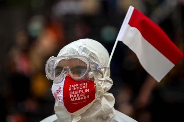 A medical worker wearing personal protective equipment (PPE) attends a ceremony to mark the country's 76th Independence Day at the Athletes Village Emergency Hospital for the coronavirus disease (COVID-19) in Jakarta, Indonesia, 17 August 2021 (Photo: Antara Foto/M Risyal Hidayat/via Reuters).