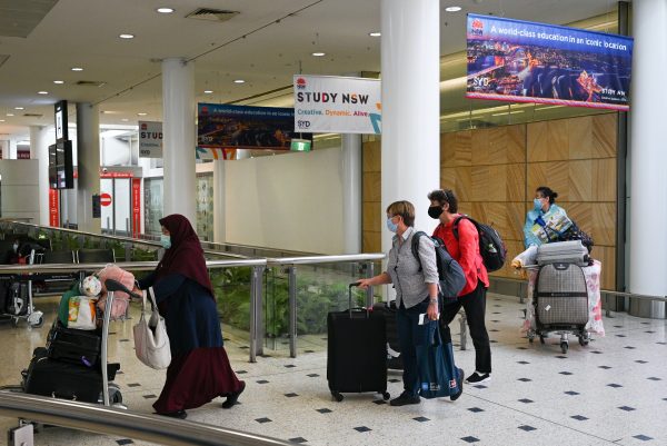 Travelers wearing protective face masks make their way through the arrivals section of the international terminal of Kingsford Smith International Airport the morning after Australia implemented an entry ban on non-citizens and non-residents intended to curb the spread of COVID-19 in Sydney, Australia, 21 March 2020 (Photo: Reuters/Loren Elliott).