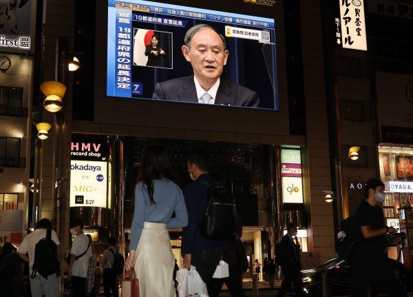 Japanese Prime Minister Yoshihide Suga makes an announcement on a large screen in Tokyo, 9 September 2021 (Photo: Yoshio Tsunoda/AFLO via Reuters).